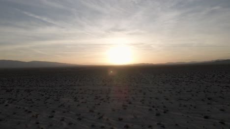 mesmerizing desert sunset viewed from a low-flying drone, capturing stunning silhouettes against the vibrant sun