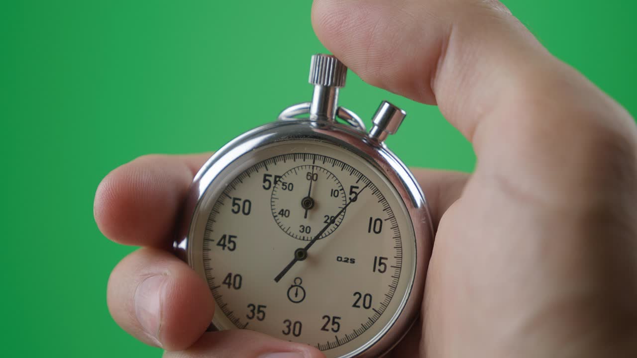 Male hand holding analogue stopwatch on green screen chroma key. Time start with old chronometer man presses start button in the sport concept. Time management concept.
