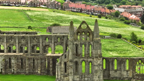 Ruinen-Der-Whitby-Abbey-In-üppiger-Grüner-Landschaft-Mit-Einem-Dorf-Im-Hintergrund