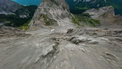 fpv drone dive down a steep mountain, overseeing the valley in tyrol region of austria