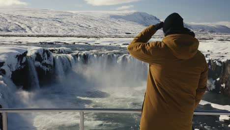 Touristen-Kommen-In-Die-Nähe-Einer-Metallsicherheitsbarriere-Und-Schauen-Sich-Die-Wasserfalllandschaft-Von-Godafoss-An