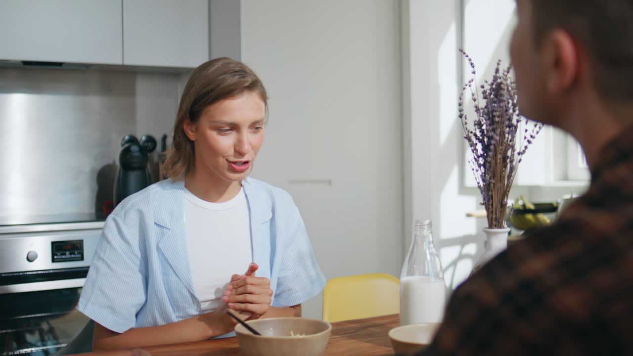 Carefree girl catching food during breakfast closeup. Married couple having fun