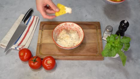 una persona que sostiene un plato de nachos sumergido en un aderezo de queso cremoso
