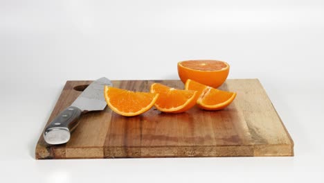 person slicing oranges on a wooden cutting board