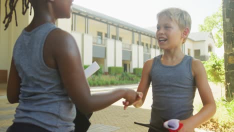 video of happy diverse boys shaking hands in front of school