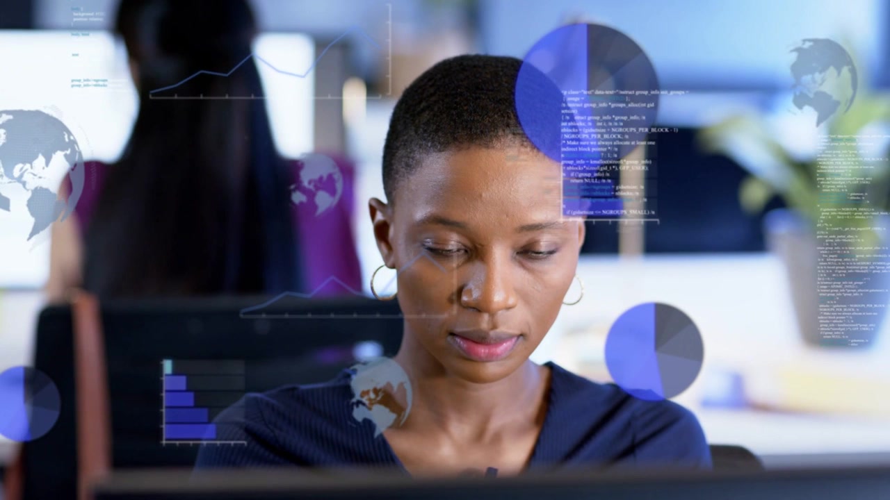 Woman at desk analyzing data on monitor, causing business overlays with pie charts and bars growing