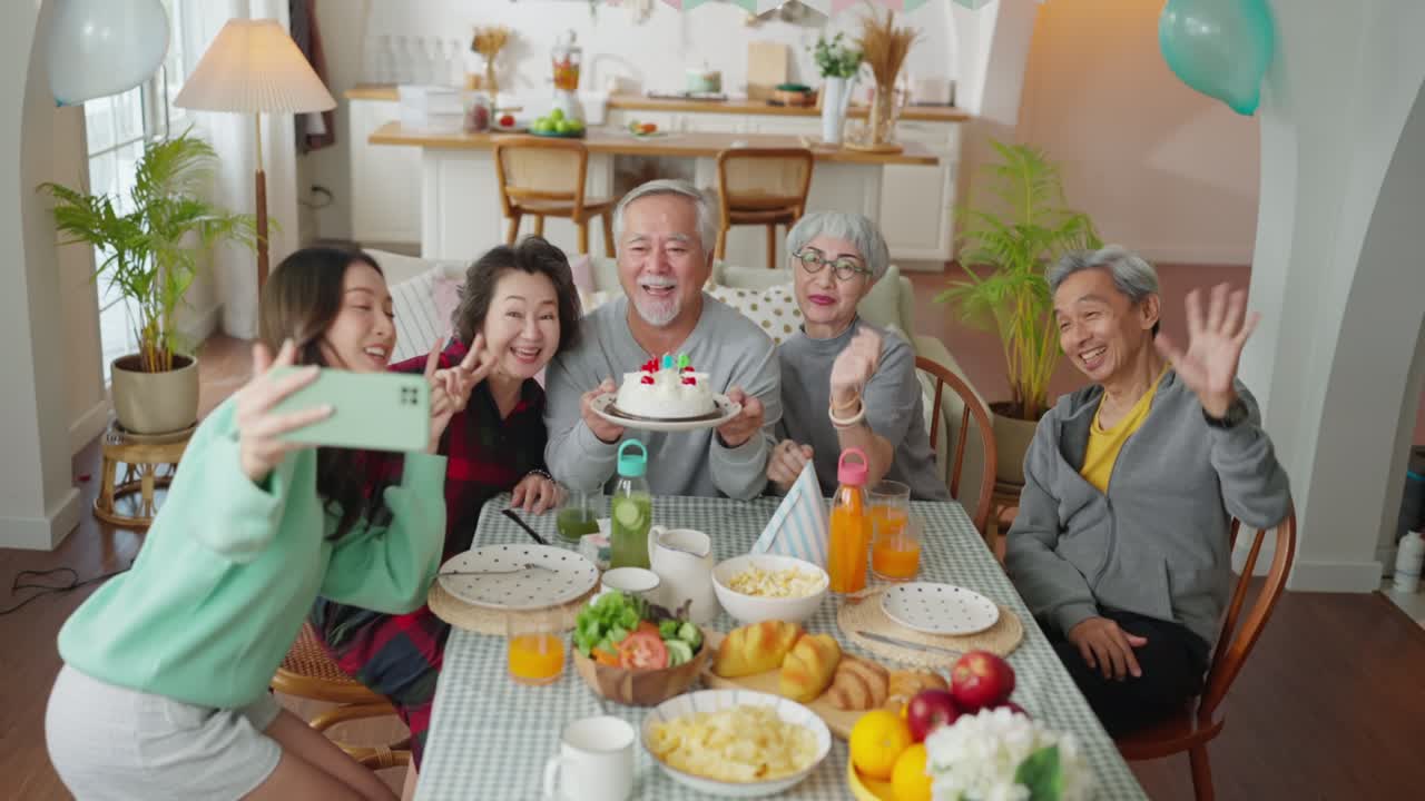 birthday party at senior daycare,group of asian female elder male female laugh smile positive conversation greeting in birthday friend party at nursing home senior group video call to family in party