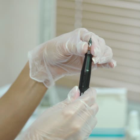 beautician is showing a brush with a needle at the end in her hands for permanent makeup. modern methods of cosmetology.