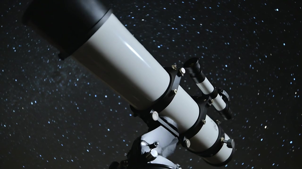 Reaching hands turning focus knob and tilting white refractor telescope at night to frame Milky Way