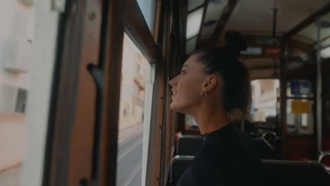 a woman riding a historical tram looking out the window