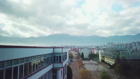 Motion-timelapse-of-the-mountain-view-from-a-school-rooftop-window-in-Denizli,-Turkey,-showcasing-the-schoolyard,-cityscape,-and-mountains