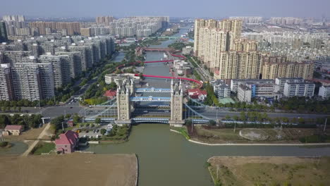 Luftaufnahme-Der-Ikonischen-Nachbildung-Der-Tower-Bridge-Am-Kanal-In-Suzhou,-China