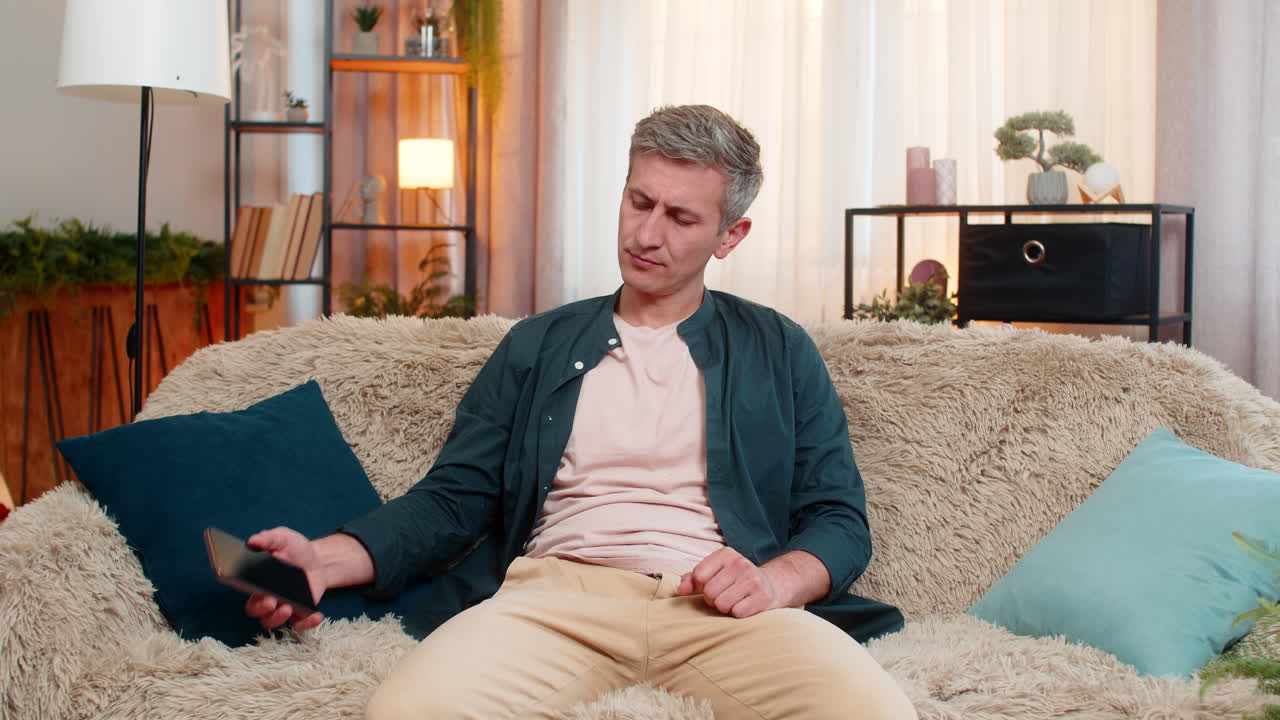 Young man puts smartphone aside with disappointment after seeing weak social media feedback response