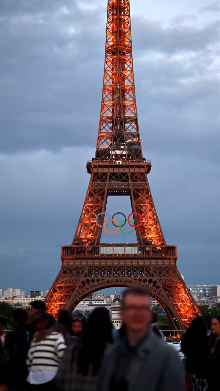 The Eiffel Tower with the Olympic Games sign sparkling in the evening in Paris, France. Vertical