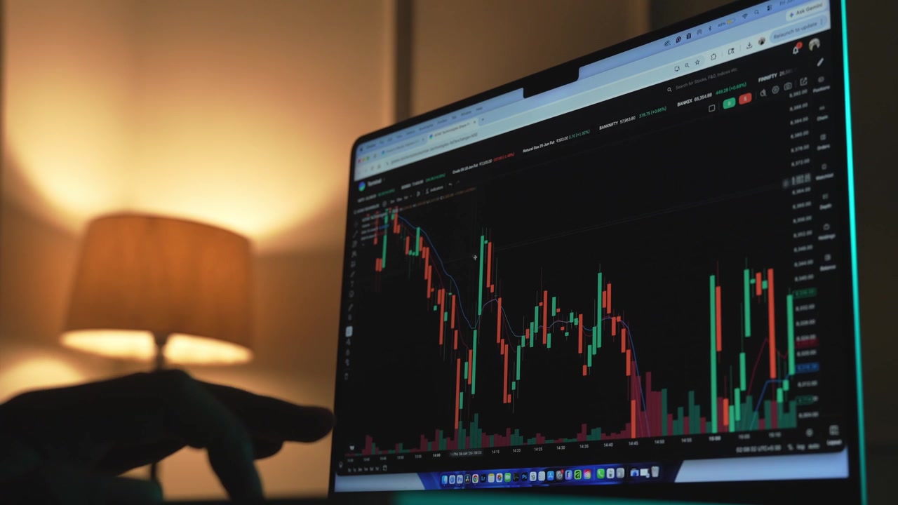 Trader che analizza grafici di borsa su un laptop tramite una piattaforma di brokeraggio