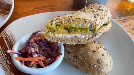 Tasty-sandwich-with-chicken,-cheese,-guacamole-and-coleslaw,-restaurant-table,-4K-shot