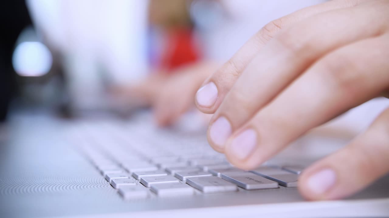 Close up of hands typing on a laptop keyboard