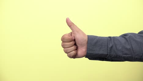 a businessman showing thumbs up on yellow background