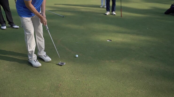 vicino alla palla, il golfista colpisce la palla con il bastone nel buco