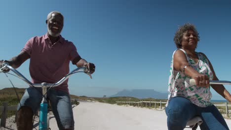 senior couple on bikes near the beach