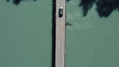 bird's eye view of a car driving over a bridge