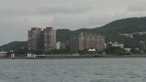 Río-Caudaloso-Y-Rascacielos-En-El-Antiguo-Muelle-De-Bali,-Taipei.