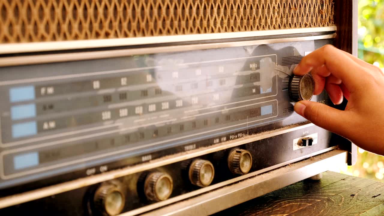 손으로 버튼을 조정하는 여자 빈티지 라디오