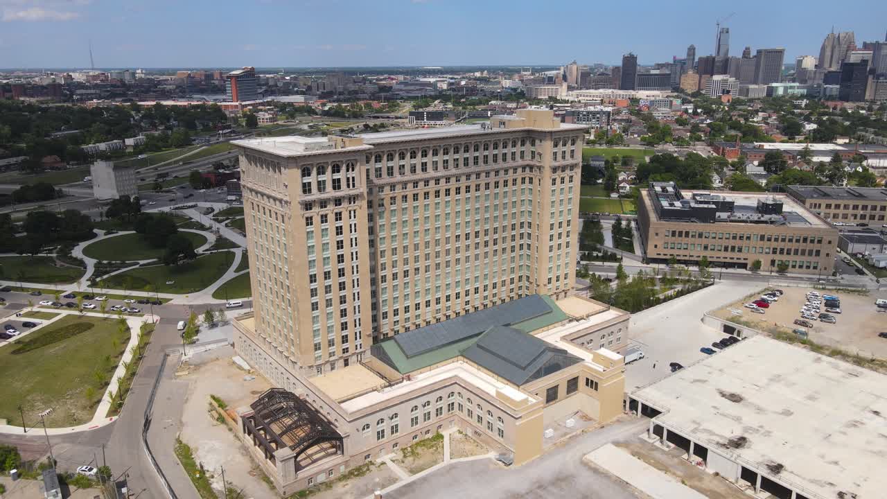 Recently restored Michigan Central Station building in Corktown with Detroit skyline in background, aerial view