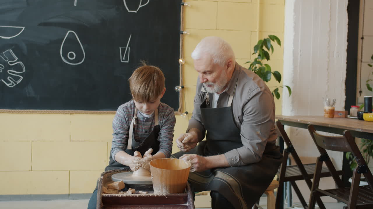 Nonno e nipote che fanno ceramica insieme