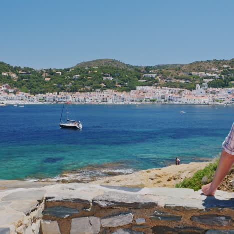 A-woman-rests-by-the-sea-near-Cadaques-in-Catalonia-2