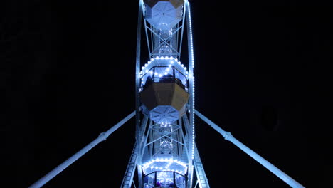 vista inferior de la gran rueda de hierro iluminada que domina la vista con cabinas de pasajeros en brno durante la noche de navidad capturada en cámara lenta de 4k 60fps