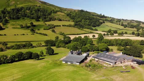 toma aérea de una granja en gales con un hermoso paisaje al fondo