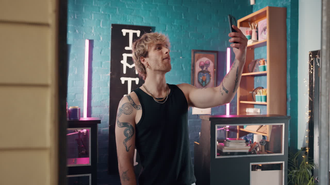 Man taking a selfie in a tattoo parlor
