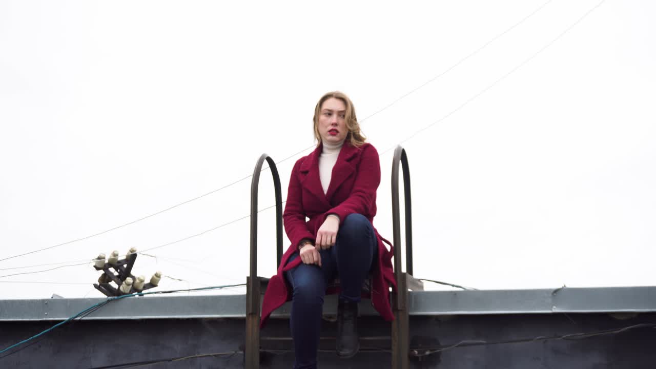 mujer sentada en la escalera del techo