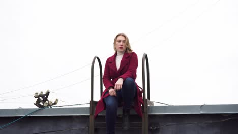 woman sitting on rooftop ladder