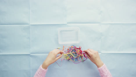 top view hands organising tangled multicolor cables desk from above - red epic dragon