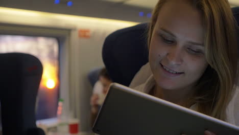 mujer sonriente con touch pad en el tren expreso