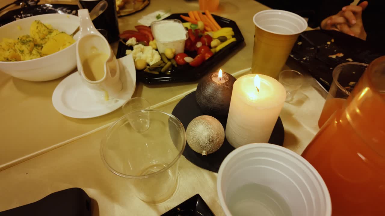 Slow camera movement over food table showing festive mood and social warmth