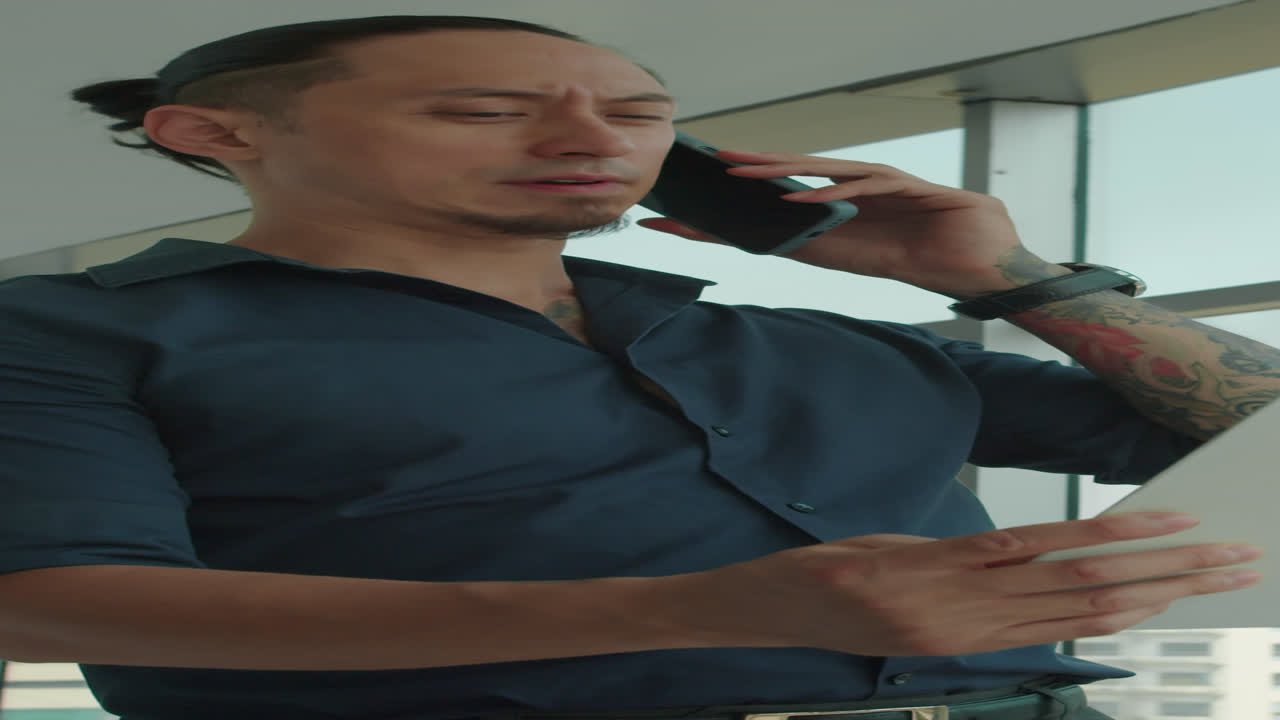 Vertical of Male Entrepreneur Calling on Phone to Confirm Terms of Contract