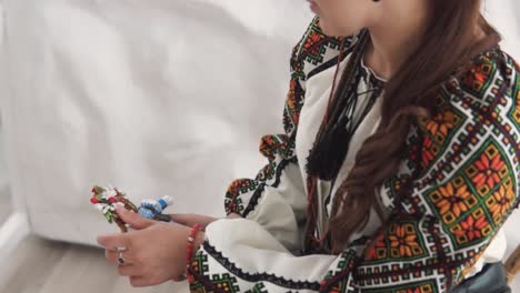 Close-up-portrait-depicts-a-charming-young-woman-in-embroidered-authentic-Ukrainian-attire-holding-a-handmade-motanka-doll