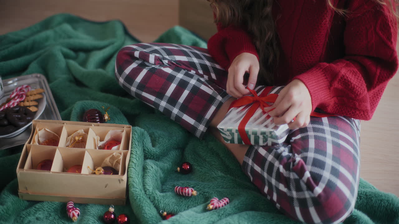 mujer envolviendo regalos de navidad en el suelo de casa
