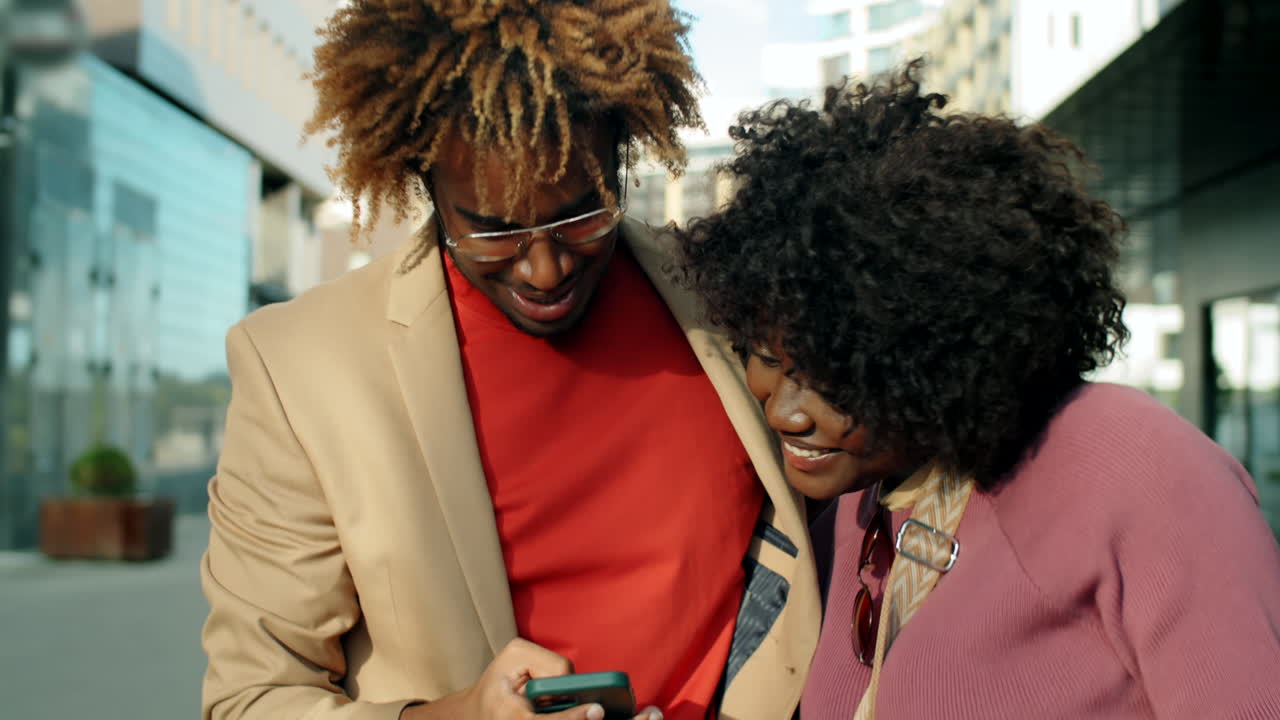 feliz pareja afroamericana tomando una selfie en la ciudad