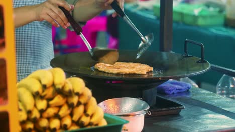 4k cinematic cooking footage of a thai chef preparing a traditionnal thai dessert called roti in a street market in thailand