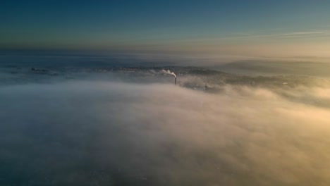 aerial drone scene above the urban townscape area shrouded in thick morning mist