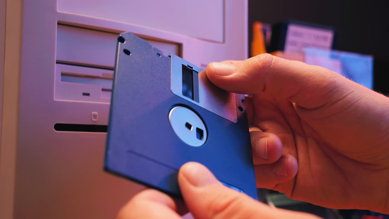 Using diskette for old computer. Music recorder, playing retro computer games. Vintage device for office, obsolete technology. . High quality 4k footage