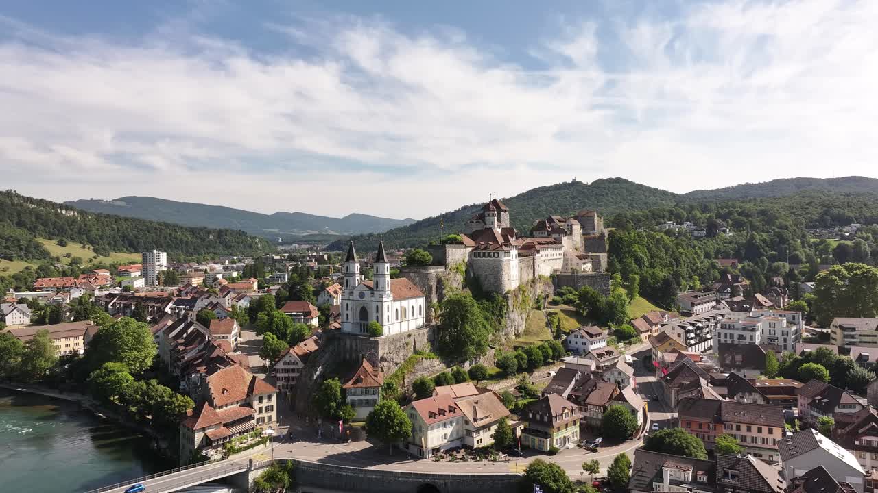 Aarburg castle on hill above Aare river in Switzerland, drone view with historic buildings, mountains and scenic summer sky