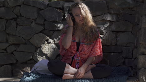 attractive and carefree blonde woman wearing headphones outdoors