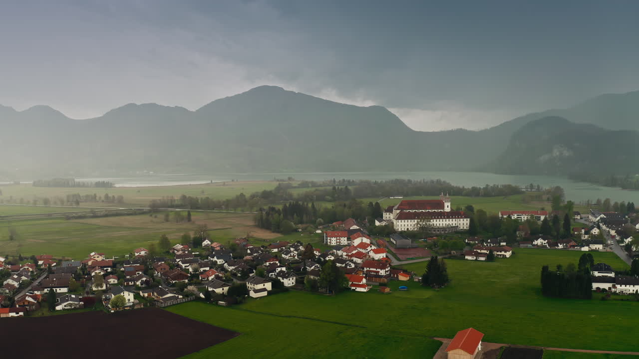 수도원, 호수, 멀리 보이는 안개 낀 산이 있는 작은 독일 바이알리지의 놀라운 공중 영상