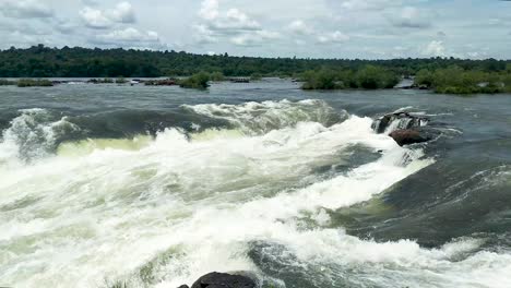 pan left over the fast flowing iguazu waterfalls into the devil's throat canyon