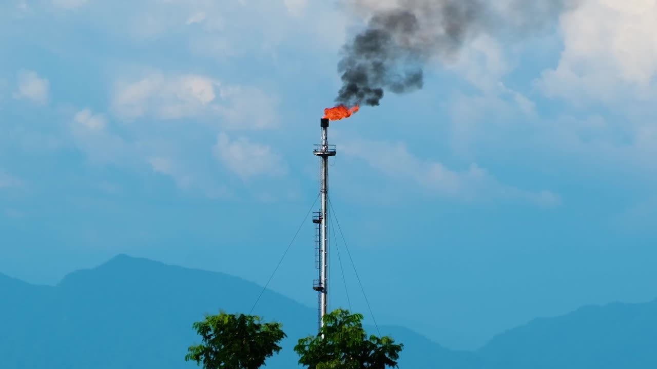 언덕 배경에 복사 공간과 함께 석유 정유소에서 과도한 가스를 태우는 플레어 스택